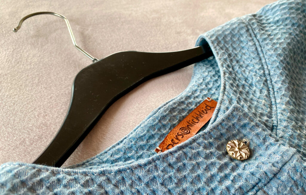 Corporate Design der Schneiderei Persönlichkleid. Foto einer geschneiderten Jacke mit Etikett.